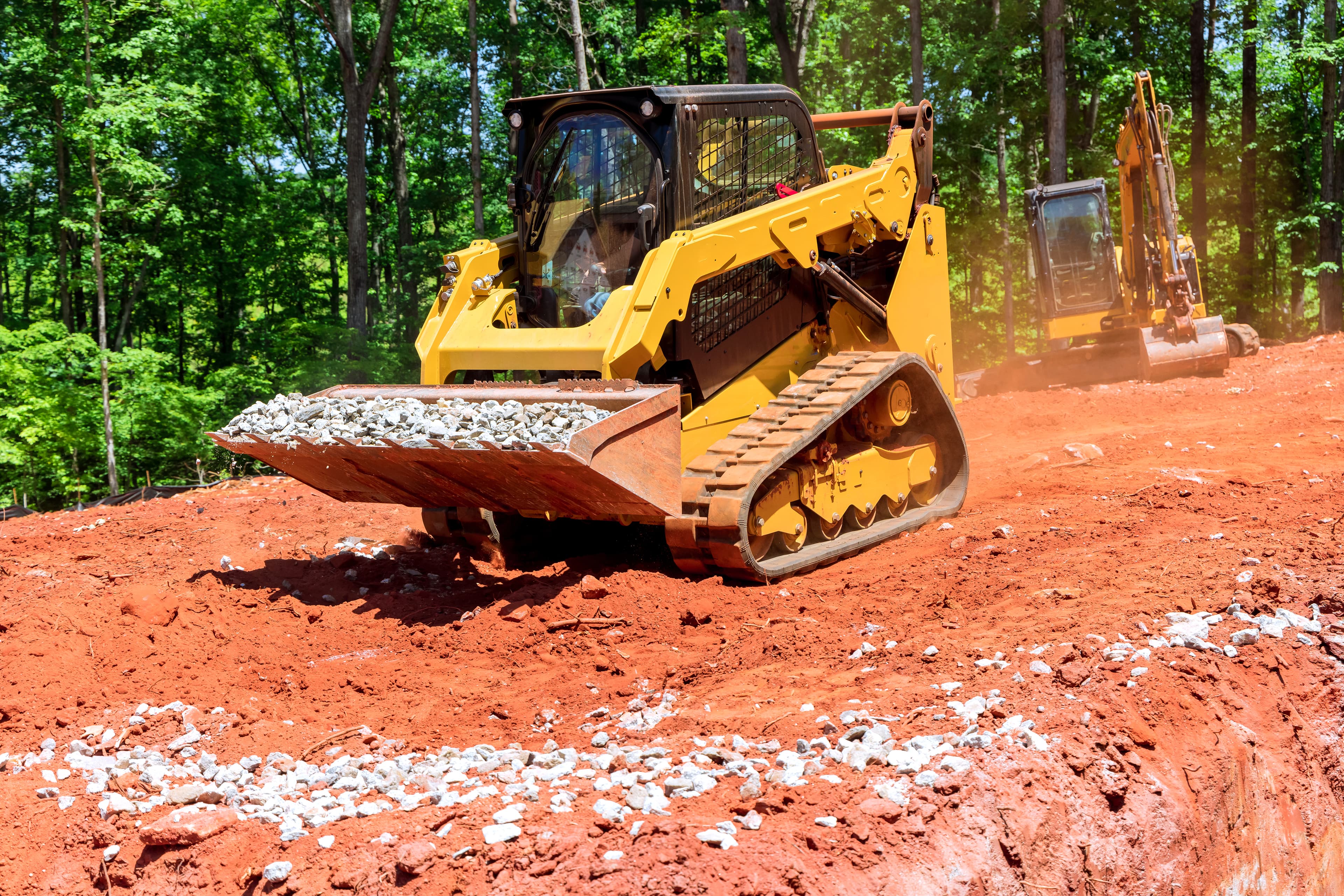 Construction equipment at work — track loader and excavator on an active job site